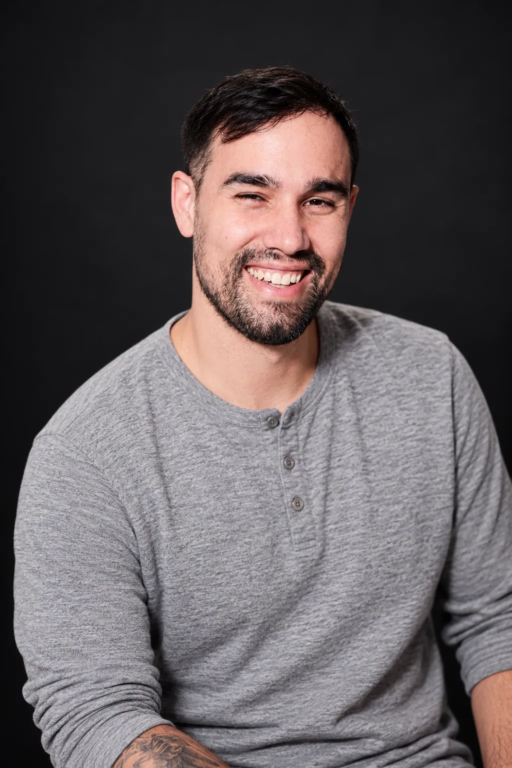 The same man in a heather gray henley studio portrait